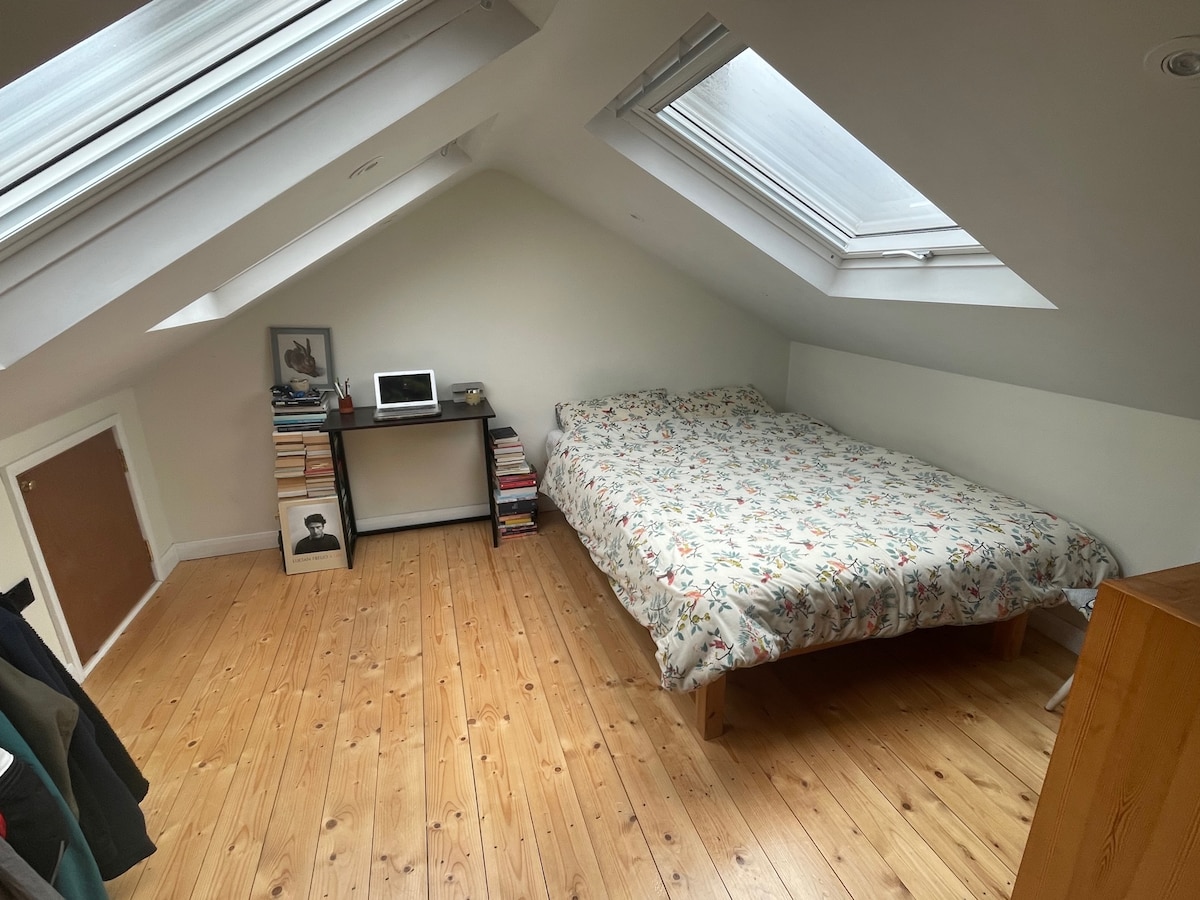 חדר שינה זוגי בלופט, עם מיטה זוגית ופוטנציאל למזרן יחיד נוסף על הרצפה