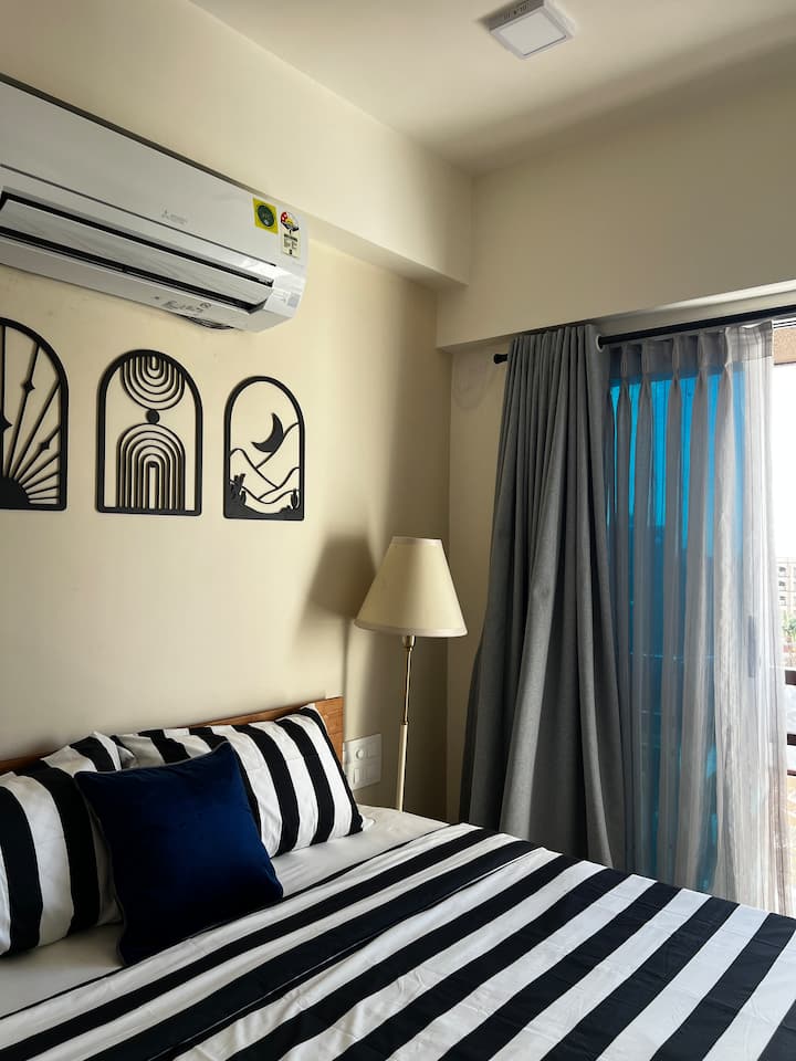 Климатизирана спалня в самостоятелен апартамент 1 BHK на 8 - ия етаж на 9 - етажна сграда. Оборудван с двойно легло king size с 10 - инчов луксозен пружинен матрак.