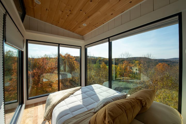 Nicknamed the glass bedroom with three sides floor to ceiling glass and amazing panoramic views of the lake and the mountains.