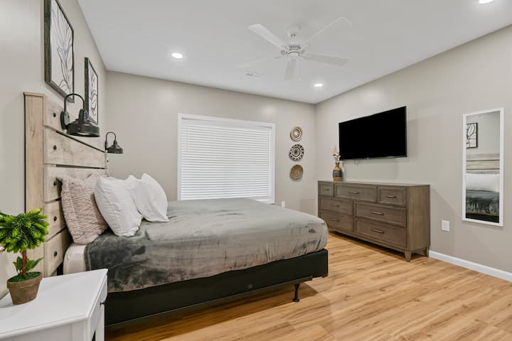 Primary suite with private bath featuring heated tile floor, located on lower level. Steps away from walkout access to deck and driveway. 