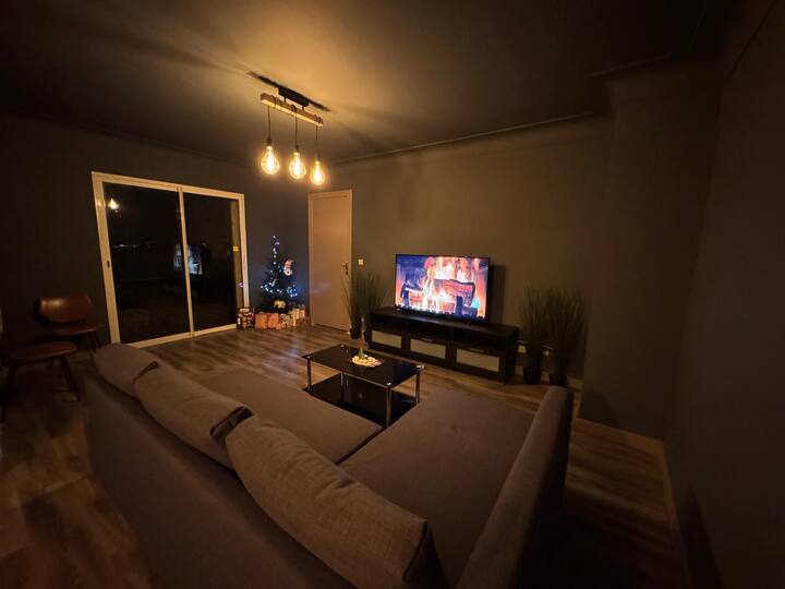 Salon la nuit avec canapé lit et télévision connectée