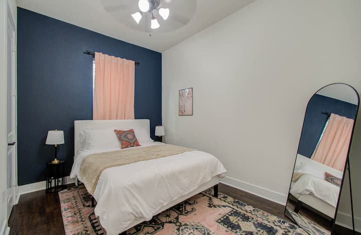 Spálňa zdobená plyšovou posteľnou bielizňou a štýlovým stojacim zrkadlom, ktoré ponúka pohodlie a nádych elegancie.