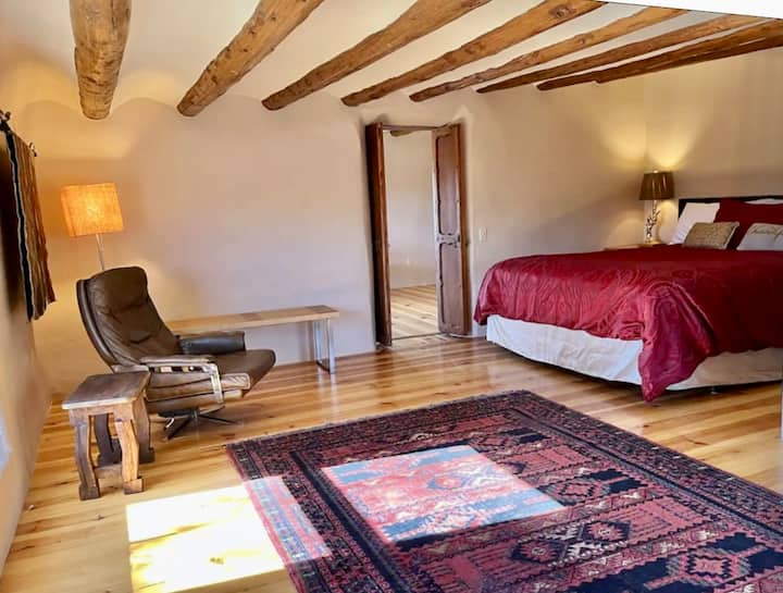 El dormitorio principal es una acogedora cueva donde el sueño perfecto está casi garantizado en suntuosas sábanas con lámparas doradas de noche para pájaros. Disfruta del tiempo en el cómodo sillón de cuero. Ten en cuenta las hermosas puertas arboladas talladas a mano.