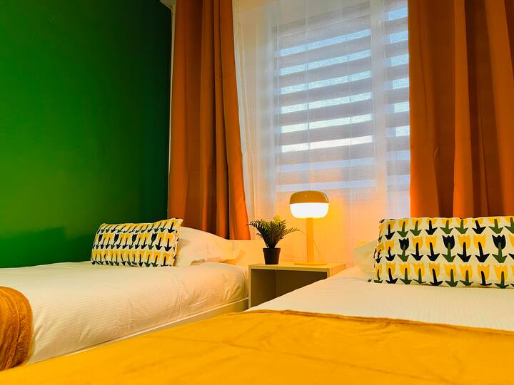 Una habitación luminosa con toques amarillos y una pared verde para un ambiente fresco y relajante.