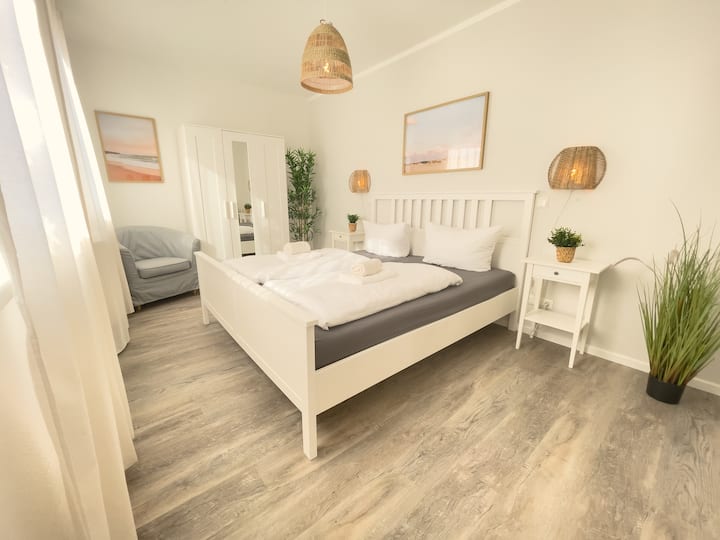 Спална соба со ламба од ратан и винилен под