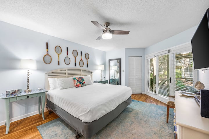 Master bedroom with comfy king size bed. Table on left can be used as a desk. Both sides have bedside tables.  A full length mirror helps getting ready. Large master closet with ironing board/luggage rack and plenty of hangers.