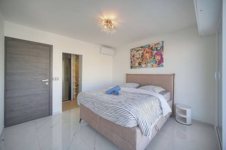 Спалната соба нуди удобен кревет со уметнички декор. Клима уредот обезбедува ладна и релаксирачка пауза по напорниот ден.