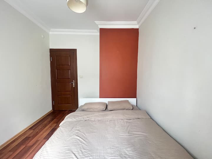 Уютна двойна спалня с чисти чаршафи и спокойна атмосфера, идеална за спокойни нощи.