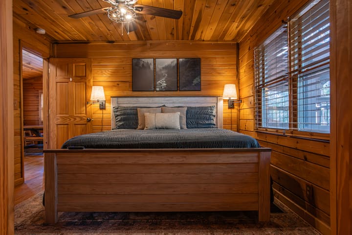 Este encantador dormitorio cuenta con detalles rústicos de madera, lujosa cama king, iluminación ambiental suave y armario para el almacenamiento. Los grandes ventanales ofrecen vistas serenas, mientras que el baño privado adjunto garantiza comodidad y privacidad para una estancia cómoda.