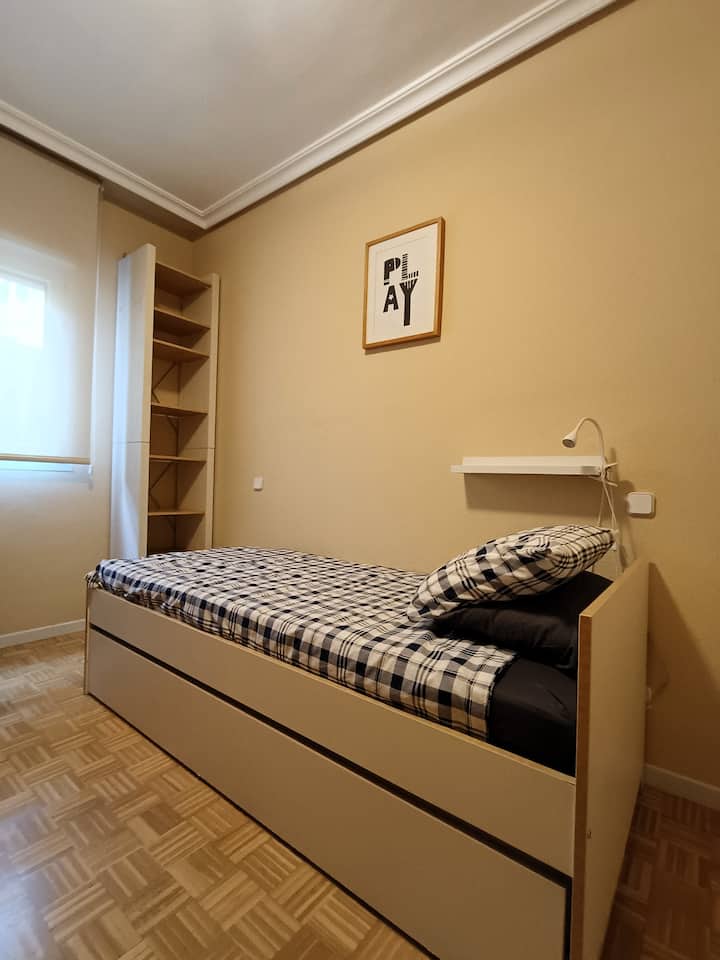 Chambre secondaire avec option d'un lit simple ou deux lits simples séparés. À l'intérieur de la chambre, il y a un espace de travail aménagé avec table et chaise ergonomique. Il dispose d'une fenêtre qui donne sur une cour intérieure très calme.