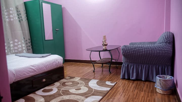 Spavaća soba s bračnim krevetom, naslonjačem i spremištem za odjeću.