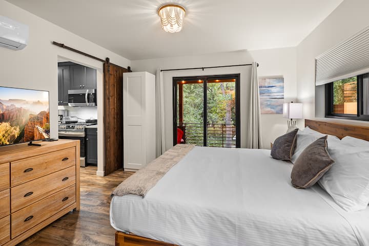 ממש ליד המטבח, דרך דלת אסם הזזה, שוכנת הסוויטה הראשית למטה עם מיטה קינג סייז לבושה במצעים יוקרתיים