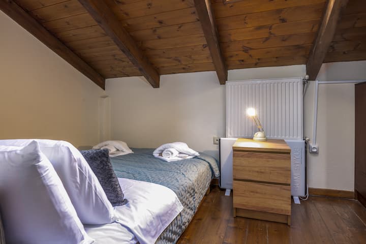 ห้องนอนใต้หลังคาที่อบอุ่นมีเพดานไม้ที่อบอุ่นและเตียงคู่ที่สะดวกสบาย เป็นที่พักที่สมบูรณ์แบบสำหรับการนอนหลับพักผ่อนผสมผสานเสน่ห์และความเรียบง่ายเพื่อการเข้าพักที่ผ่อนคลายอย่างแท้จริง