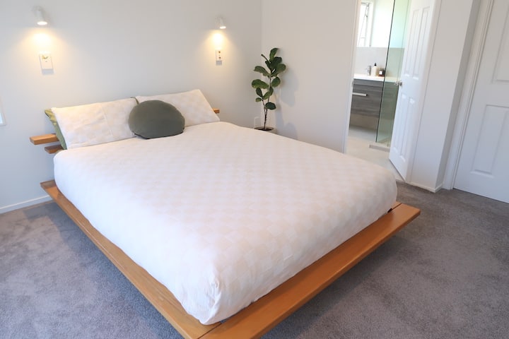 ห้องนอนใหญ่พร้อมห้องน้ำในตัวและประตูฝรั่งเศสเปิดออกสู่สวน