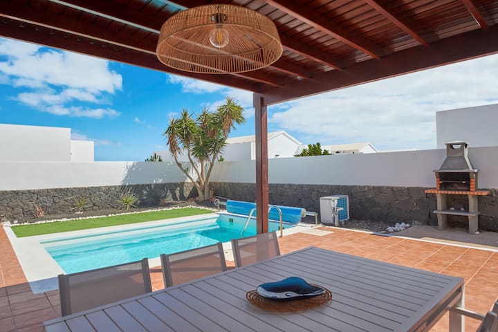 Comedor exterior, barbacoa y piscina climatizada en Casa Nolva