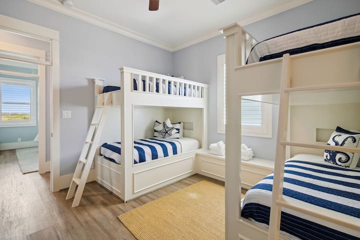 A dream room for kids! This cozy bunk bedroom with four custom-built twin beds and a private en-suite bathroom is the perfect space for endless laughter and relaxation.