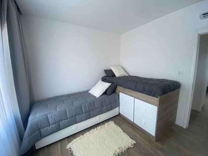 Спална соба со поглед напред опремена со 3 кревета, душеци, перници и сосема нова постелнина. 
Плакат со фиоки и простор за закачување.
AA Frio / Heat.