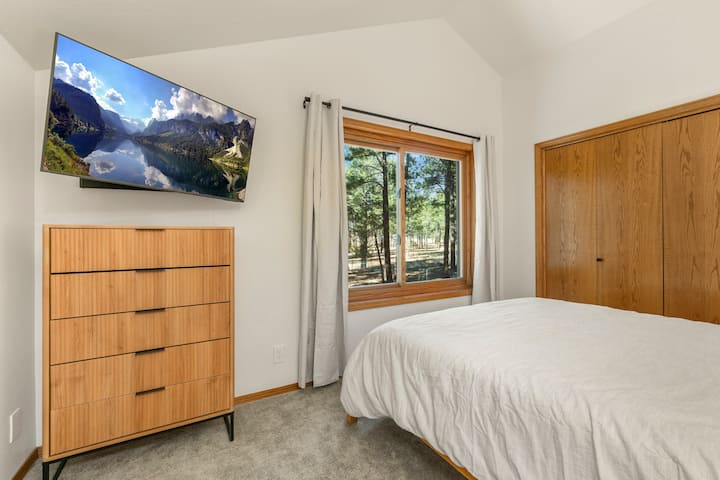 تحتوي غرفة النوم في الطابق الثاني على تلفزيون خاص ومساحة تخزين واسعة لممتلكاتك وإطلالات جميلة على الغابة