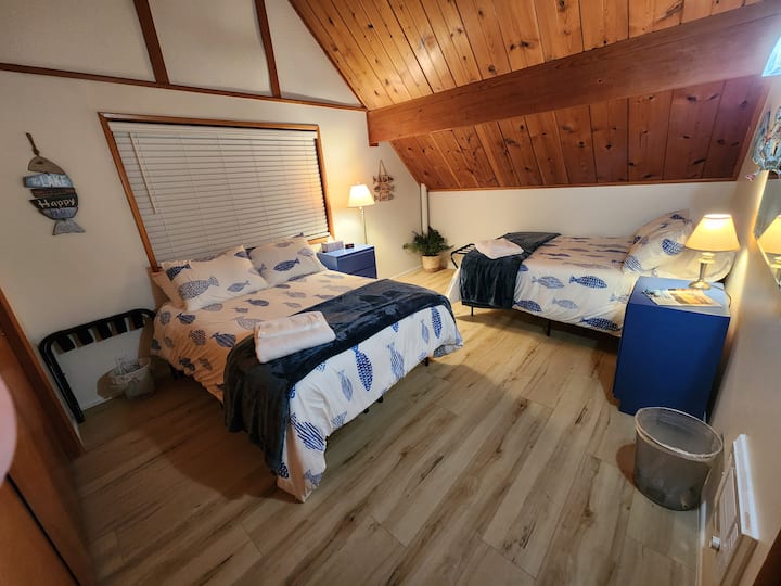 غرفة نوم كبيرة في الطابق العلوي مع سريرين مزدوجين وخزانة كبيرة.