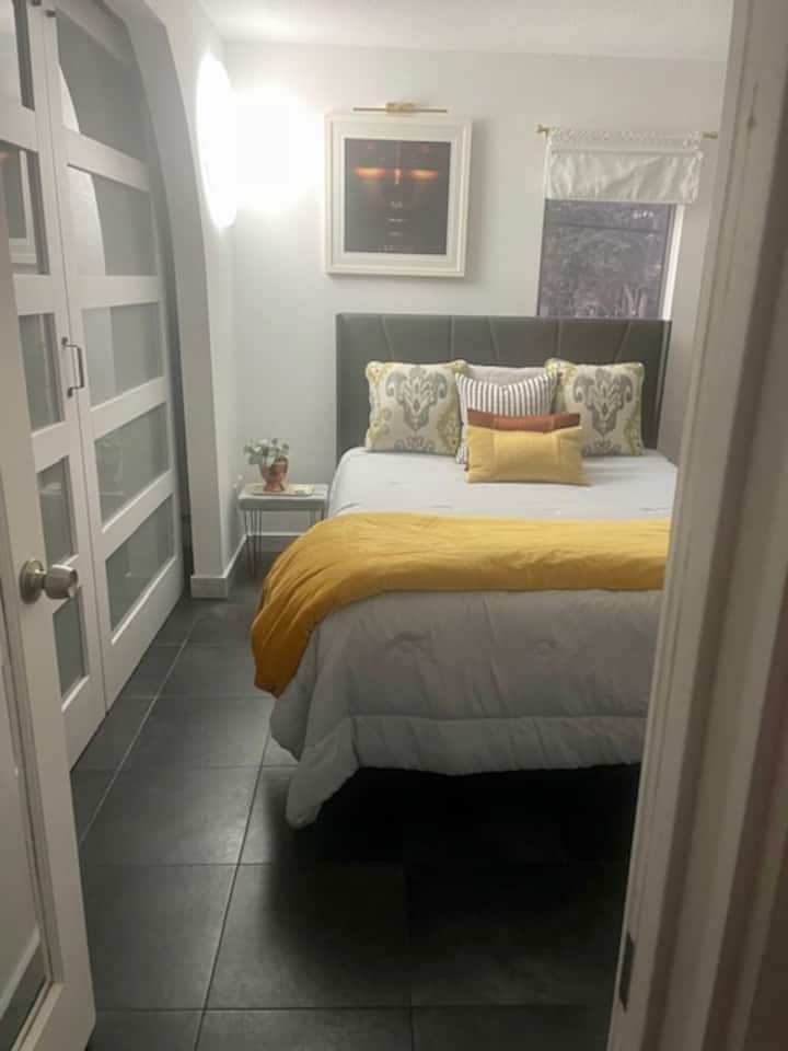 غرفة النوم الثانية ؛ سرير بحجم كوين، تلفزيون مثبت على الحائط، باب حظيرة لحجز غرفة مع مكتب.