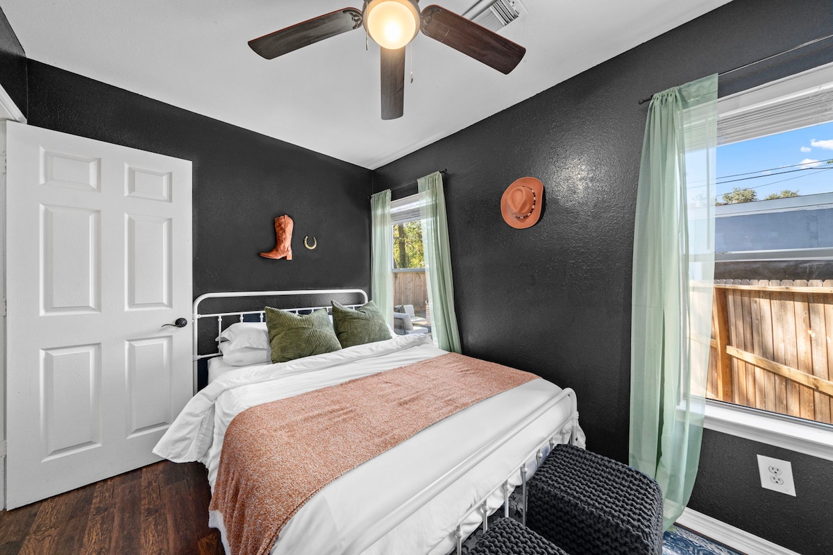 La chambre 3 dispose d'un lit queen size, d'un ventilateur de plafond et de fenêtres avec rideaux, créant une retraite confortable et confortable.