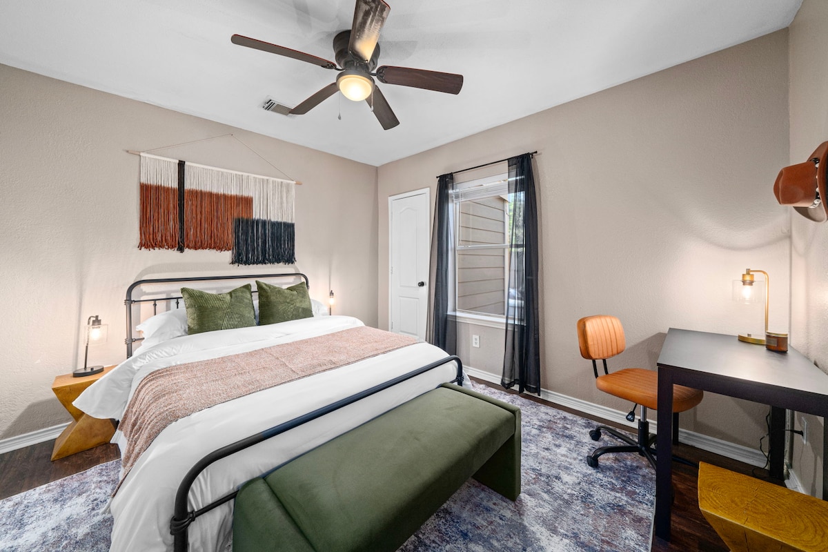 La chambre comprend un espace de travail dédié et un ventilateur de plafond, créant un endroit confortable pour le travail ou la détente.