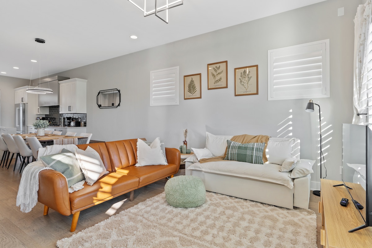 غرفة معيشة أنيقة وجذابة مع أريكتين مريحتين تتحولان إلى أسرّة متوسطة الحجم وتلفزيون ذكي 43بوصة.