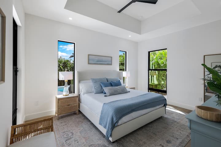 Primárna spálňa s pobrežnou tematikou s plyšovou manželskou posteľou King a upokojujúcimi tónmi. Užite si vlastnú kúpeľňu s vlastnou kúpeľňou a oddýchnite si v pokojnom priestore navrhnutom na oddych a relaxáciu po dni strávenom na slnku.