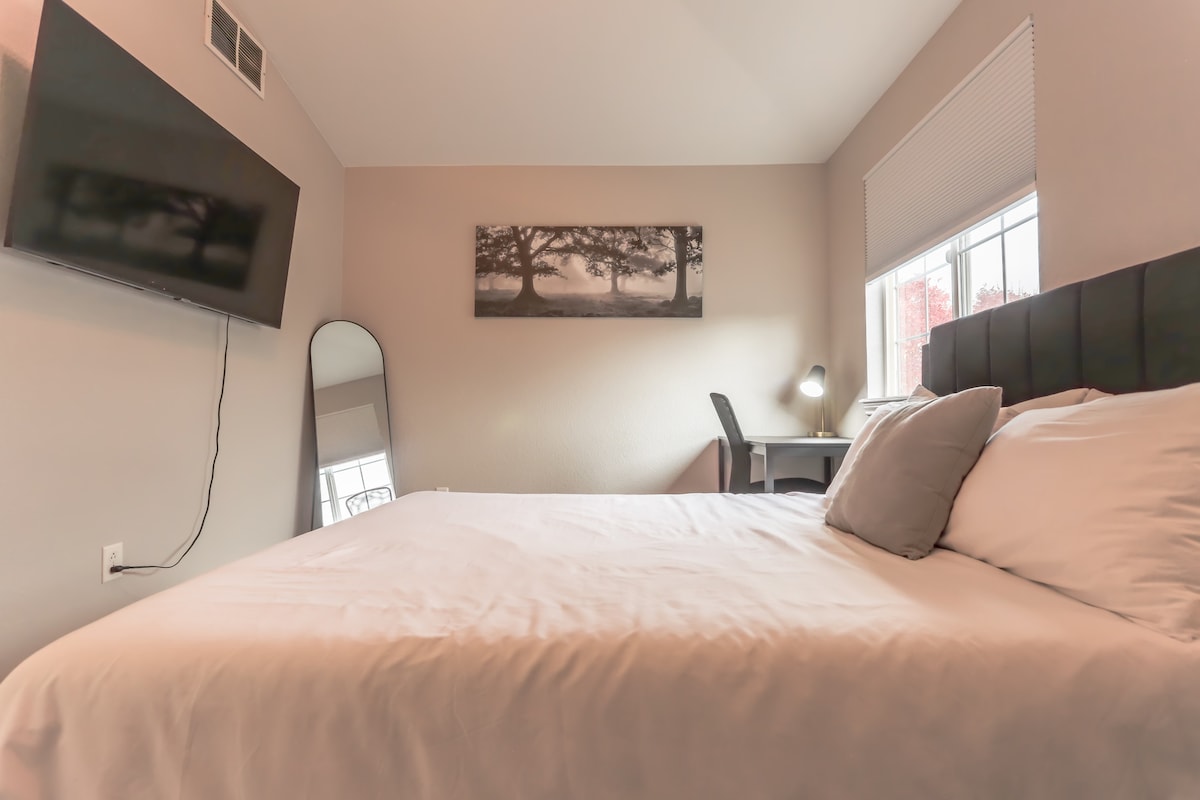 El segundo dormitorio ofrece una cama tamaño queen, espacio de trabajo y TV. Esta habitación también tiene un baño privado adjunto. 