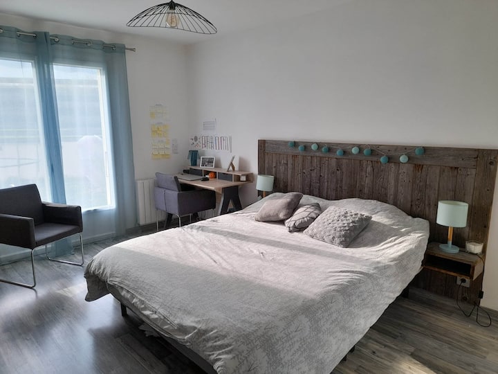 Chumba cha kwanza cha kulala na kitanda chake cha ukubwa wa kifalme na eneo la ofisi