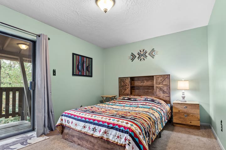 Dormitorio principal con una cama tamaño queen y un hermoso patio