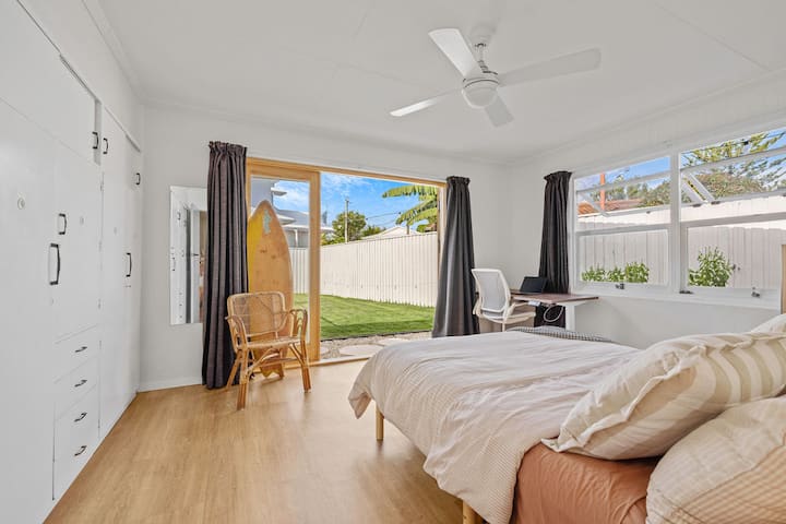 Quarto 2: Cama queen com um grande guarda-roupa e acesso direto à piscina e ao jardim. Desfrute da bela luz matinal voltada para o leste e para o norte. Possui um espaço de estudo dedicado com uma mesa de stand-up.