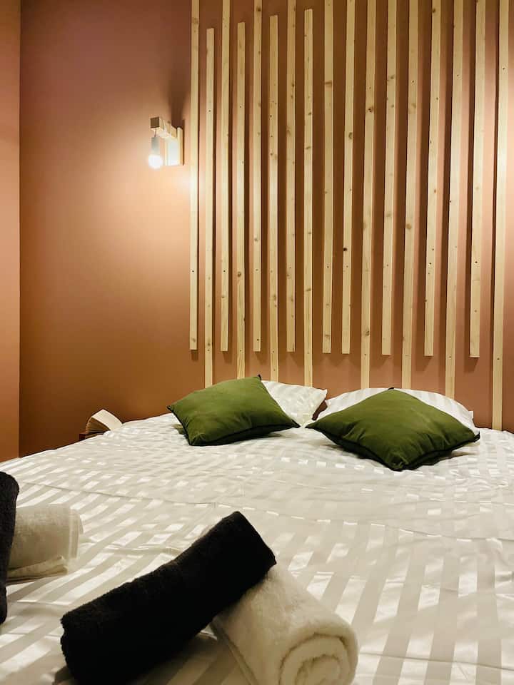 La habitación, adornada con delicados tonos tierra quemada y tazas de madera, crea un ambiente cálido y relajante, perfecto para relajarse.