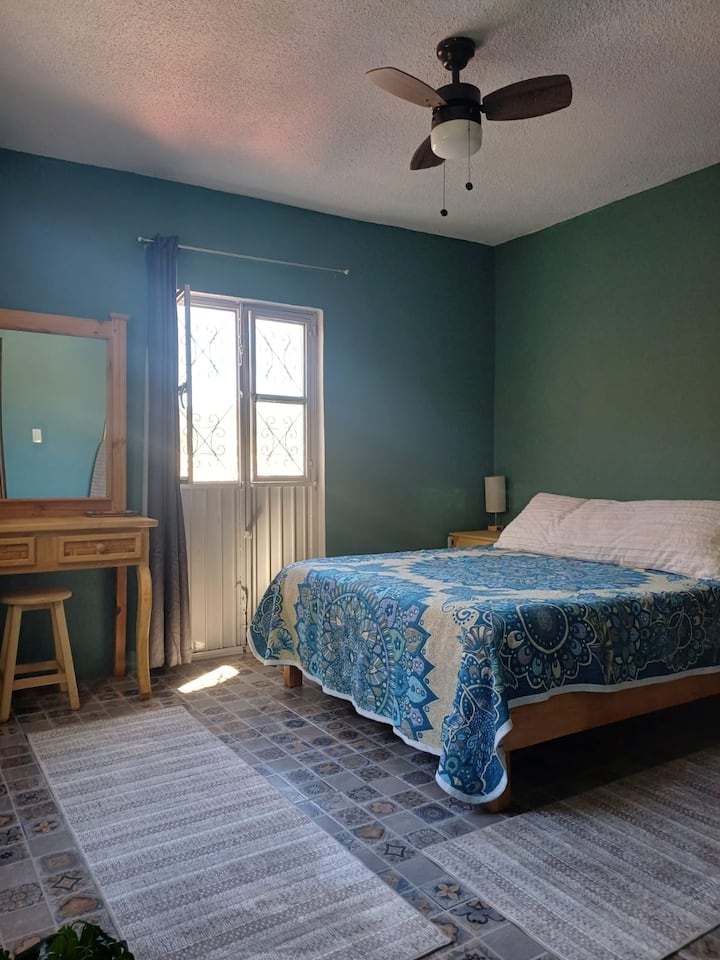 Dette soveværelse har en queensize-dobbeltseng, toiletbord, udgang til en privat balkon og et fælles badeværelse med en fremragende udsigt over byen.