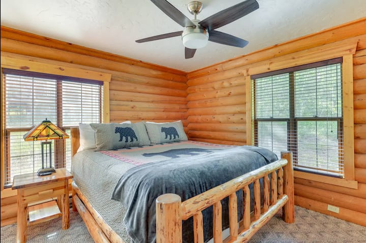 A wood-paneled bedroom with a king bed and basic furnishings, offering a space for guests to rest.