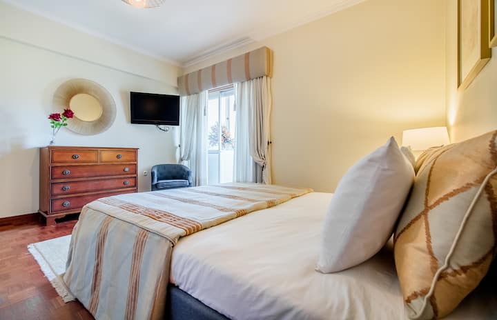 חדר 01 עם מיטה זוגית וטלוויזיה עם מסך שטוח.