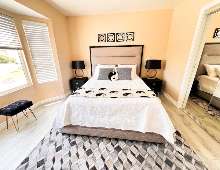 חדר שינה מסוגנן עם מיטת קווין סייז, עיצוב אלגנטי ותאורה רכה. הפנים היפה יוצר אווירה שלווה ומזמינה מושלמת ללילות נינוחים ורוגע.