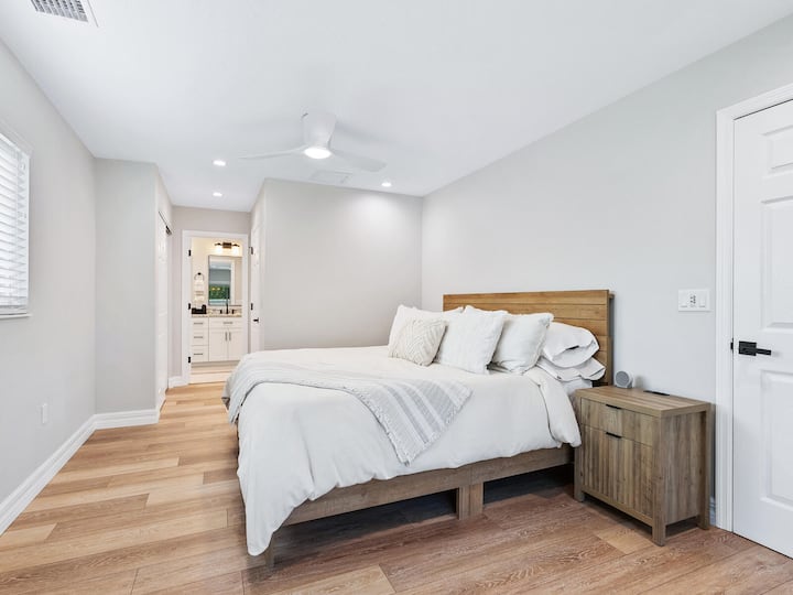 The master bedroom which is a spacious retreat designed for comfort and relaxation. The room features a king-sized bed with plush bedding, ensuring a restful night’s sleep.  Located on the opposite side of the house from the two guest bedrooms.