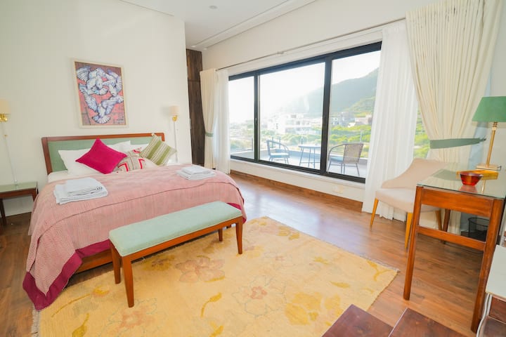 Geräumig und ruhig – entspanne dich in einer Master-Suite mit gemütlicher Bettwäsche, malerischen Fenstern und einer ruhigen Atmosphäre.

