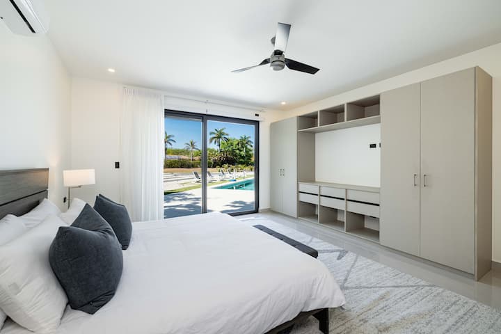 Relájate en nuestra espaciosa suite principal. La lujosa cama tamaño king con sábanas de primera calidad garantiza un sueño reparador. Baño privado para mayor comodidad. Despiértate con impresionantes vistas desde dos terrazas. Las cortinas opacas y el amplio almacenamiento completan este refugio sereno.