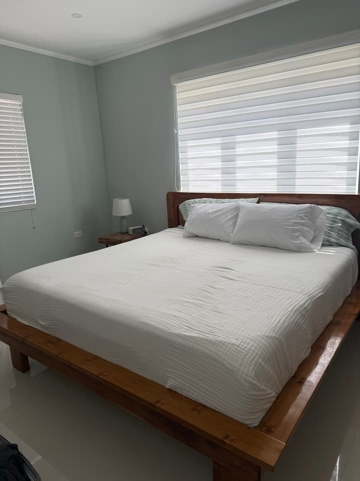 La suite principale comprend un lit king confortable, une commode, un espace de travail, une armoire et une salle de bain complète. 