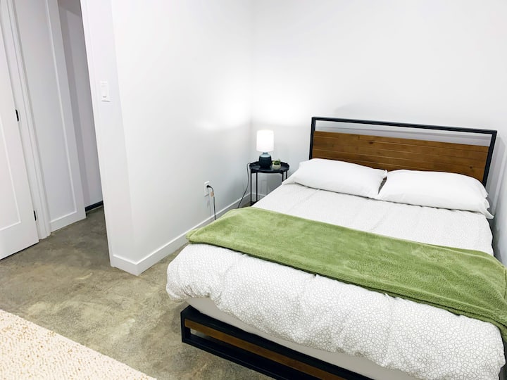 Bedroom 2 provides a spacious layout with a double bed Tuft & Needle mattress (medium-firm feel), comfortable memory foam pillows, a cozy rocker, and plenty of clothing storage.