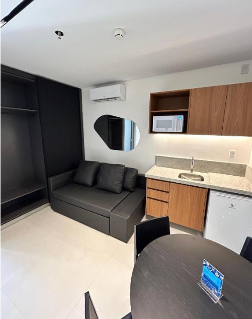 Малка стая с маса за хранене и интегрирана кухня с микровълнова печка и минибар