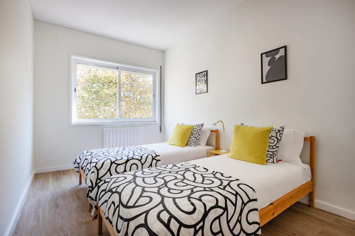 חדר שינה עם שתי מיטות יחיד וארון.