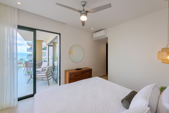 Chambre principale : porte coulissante sur le balcon avec lit king size , climatisation , ventilateur de plafond, placard et salle de bain privée.