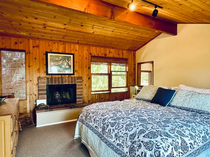 غرفة النوم الرئيسية في الطابق العلوي.  سرير كبير ومدفأة وأبواب فرنسية على سطح خاص يحتوي على طاولة أريكة ومظلة.  من الرائع الاستمتاع بالمحيط وغروب الشمس 