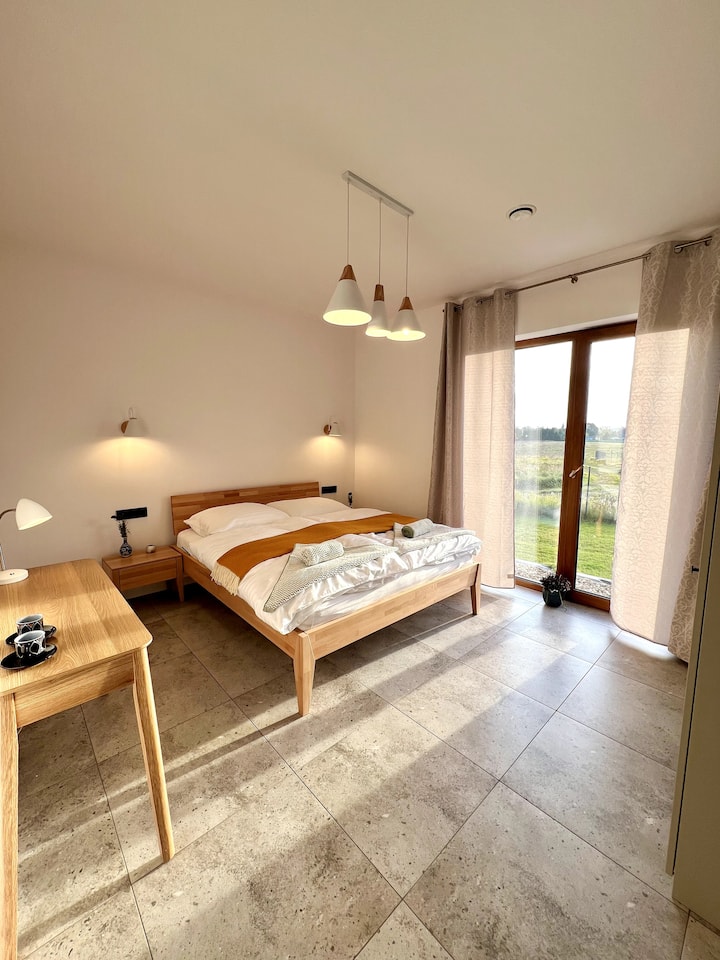 Dormitorio en la planta baja con cama doble, armario y consola de trabajo.