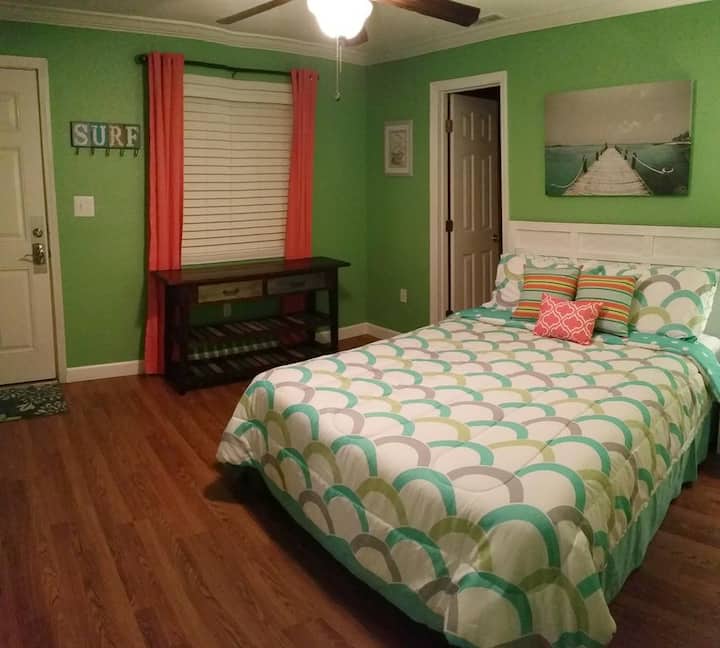 Spálňa so 50-palcovým televízorom.  Zadné dvere vedú na pláž.