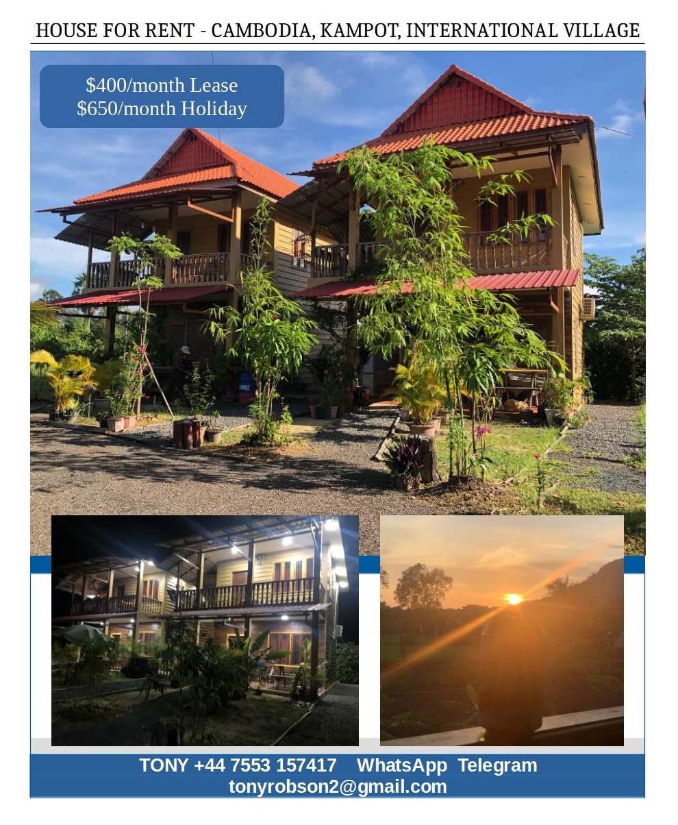 A two-story wooden structure is seen amidst a natural setting, featuring an inviting porch and vibrant greenery. The image includes glimpses of a sunset, highlighting the peaceful ambiance, with outdoor seating areas surrounded by lush plants.