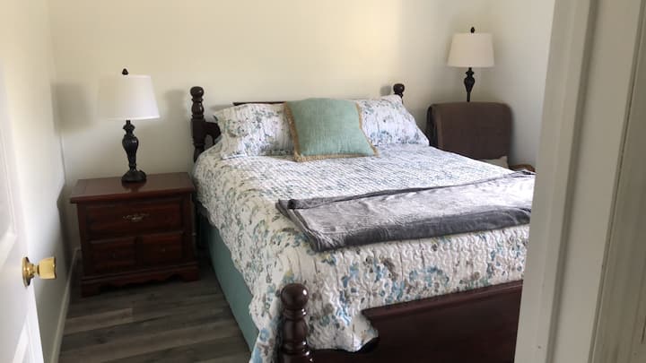 Downstairs bedroom with a queen sized bed .